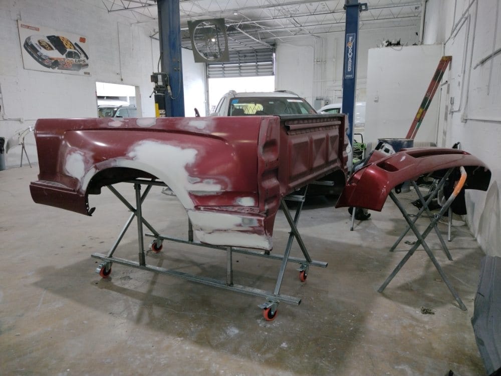 Truck bed panel with body filler being shaped before refinishing